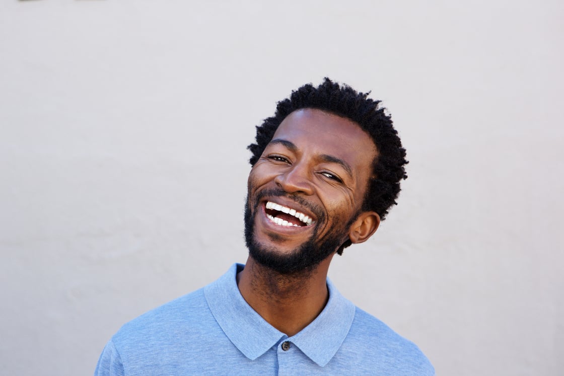 Handsome African American Man Smiling by White Wall